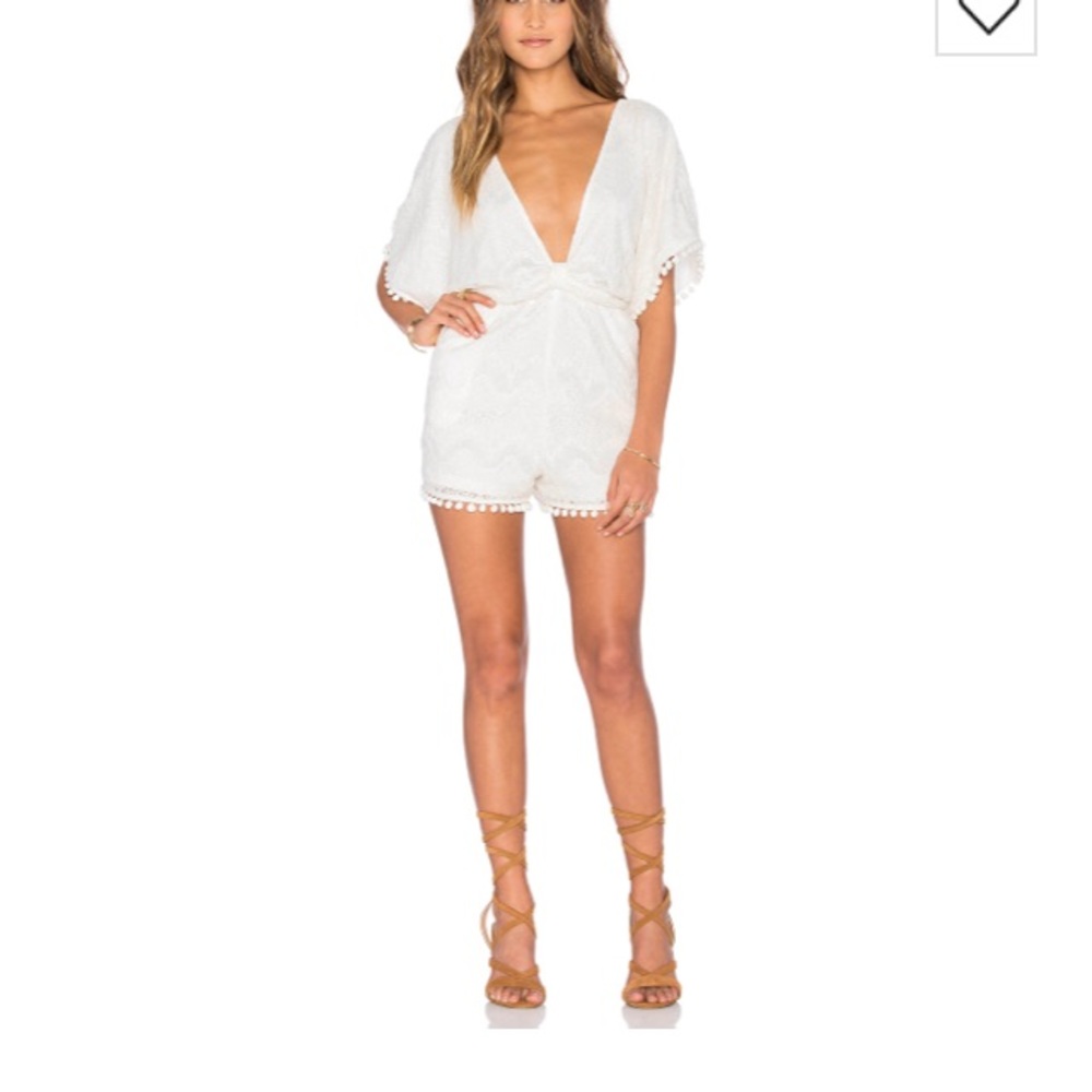 White romper with pom poms